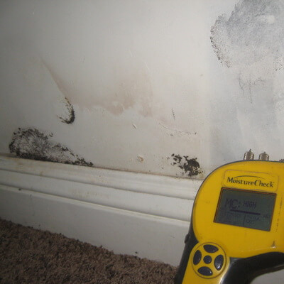 A view of the damaged wall and equipment for moisture check